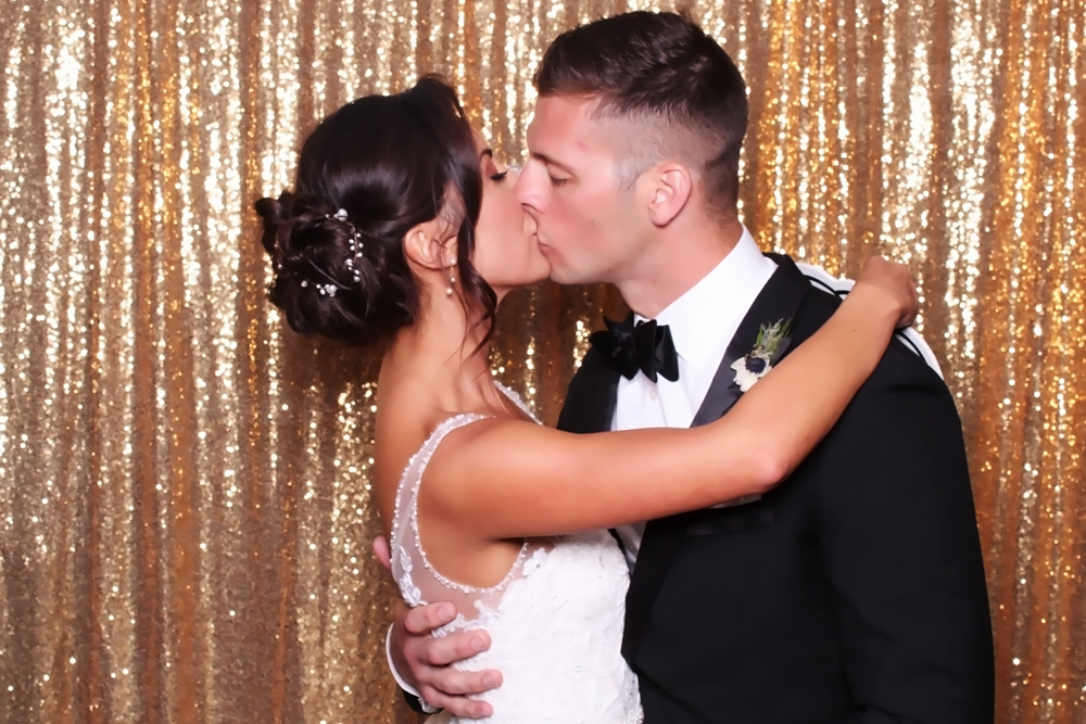 This newlywed couple having one of their first kiss as a married couple in our wedding photo booth at the Marriott in San Ramon