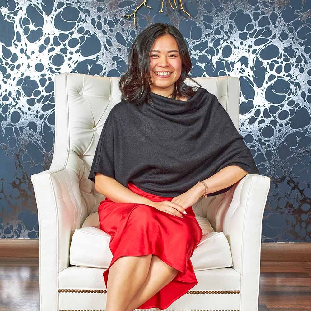 a woman sitting in elegant white chair for professional portrait taken in SF Bay Area