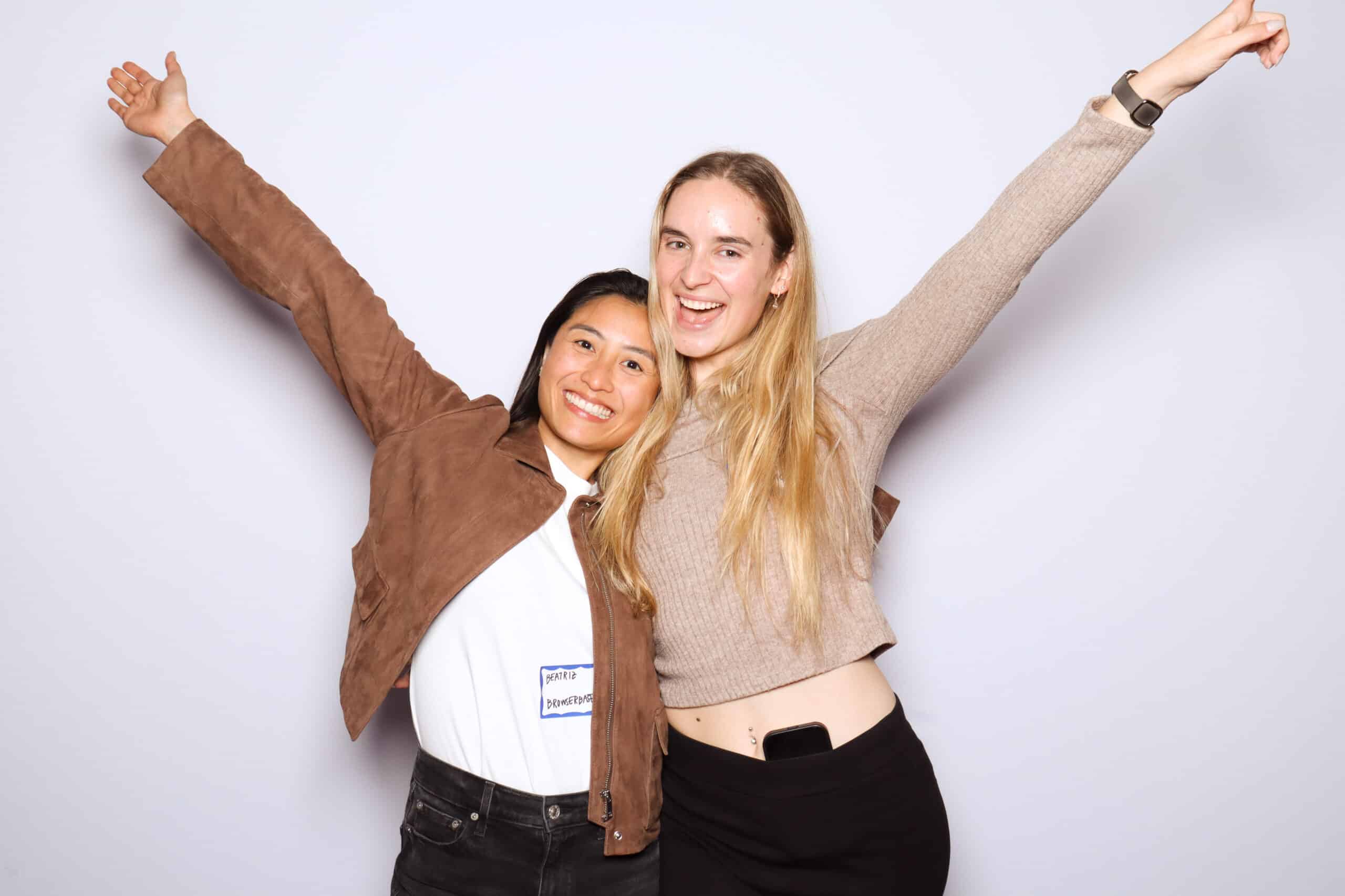 Guests smiling and celebrating in branded photo booth, corporate event experience.