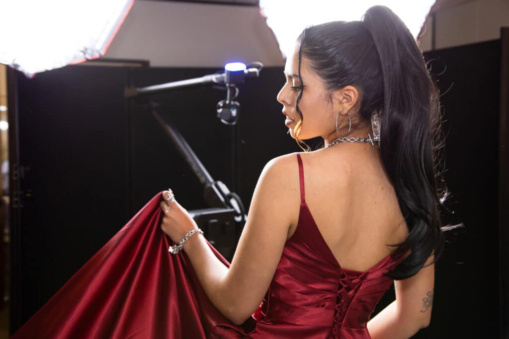 Woman in red dress and high ponytail posing for a photo with a Glambot-X