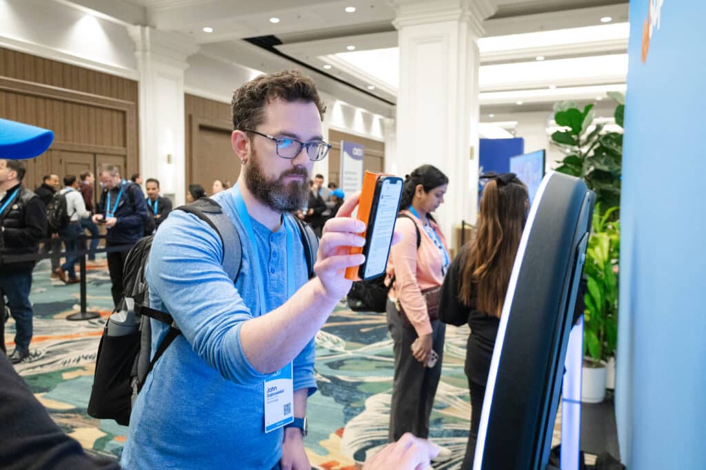 a person using their phone to interact with an AI photo booth
