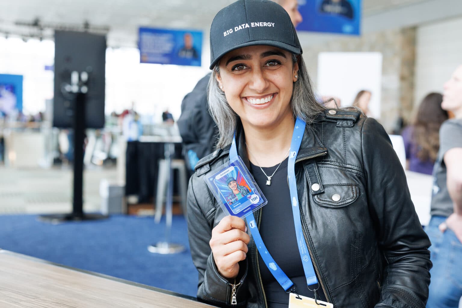Tradeshow attendee holding branded photo booth card, capturing qualified leads and enhancing brand visibility.