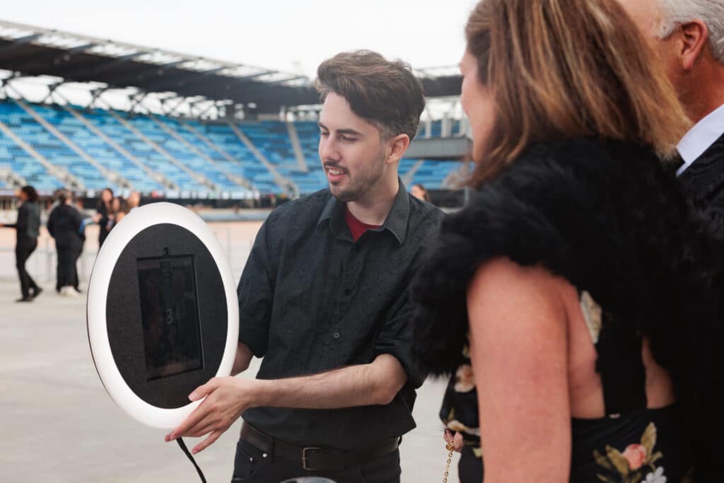 people gathered around a 360 photo booth
