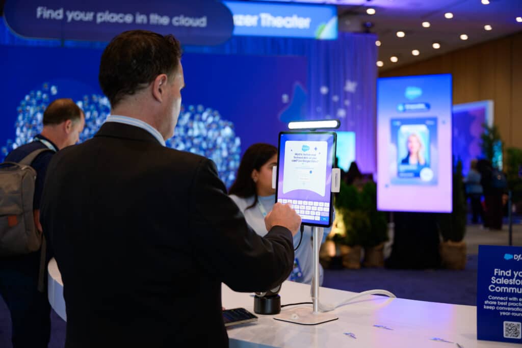 Attendee interacting with Pop Life Photo's AI trading card activation at Dreamforce 2026, showcasing personalized