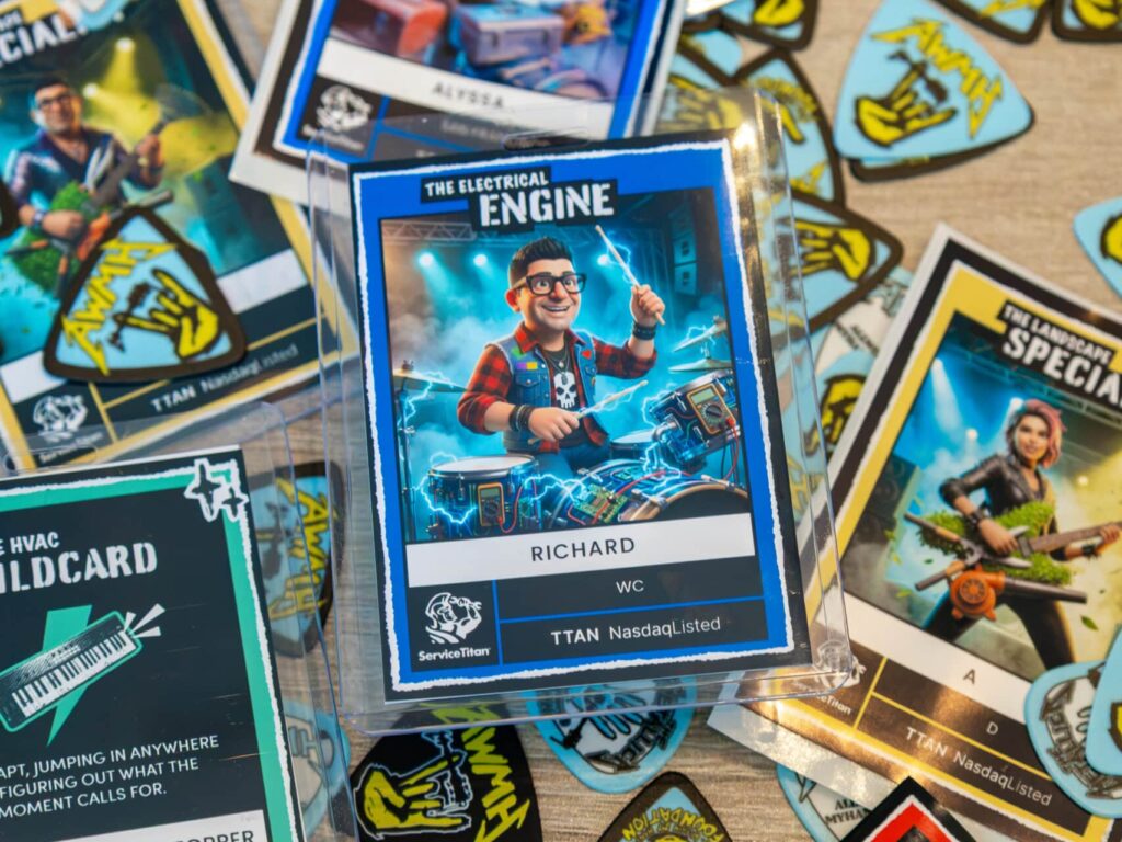 ServiceTitan rock-themed trading cards with cartoon tradespeople as musicians, including "The Electrical Engine" card of a drummer named Richard in a clear case, scattered among guitar-pick stickers.